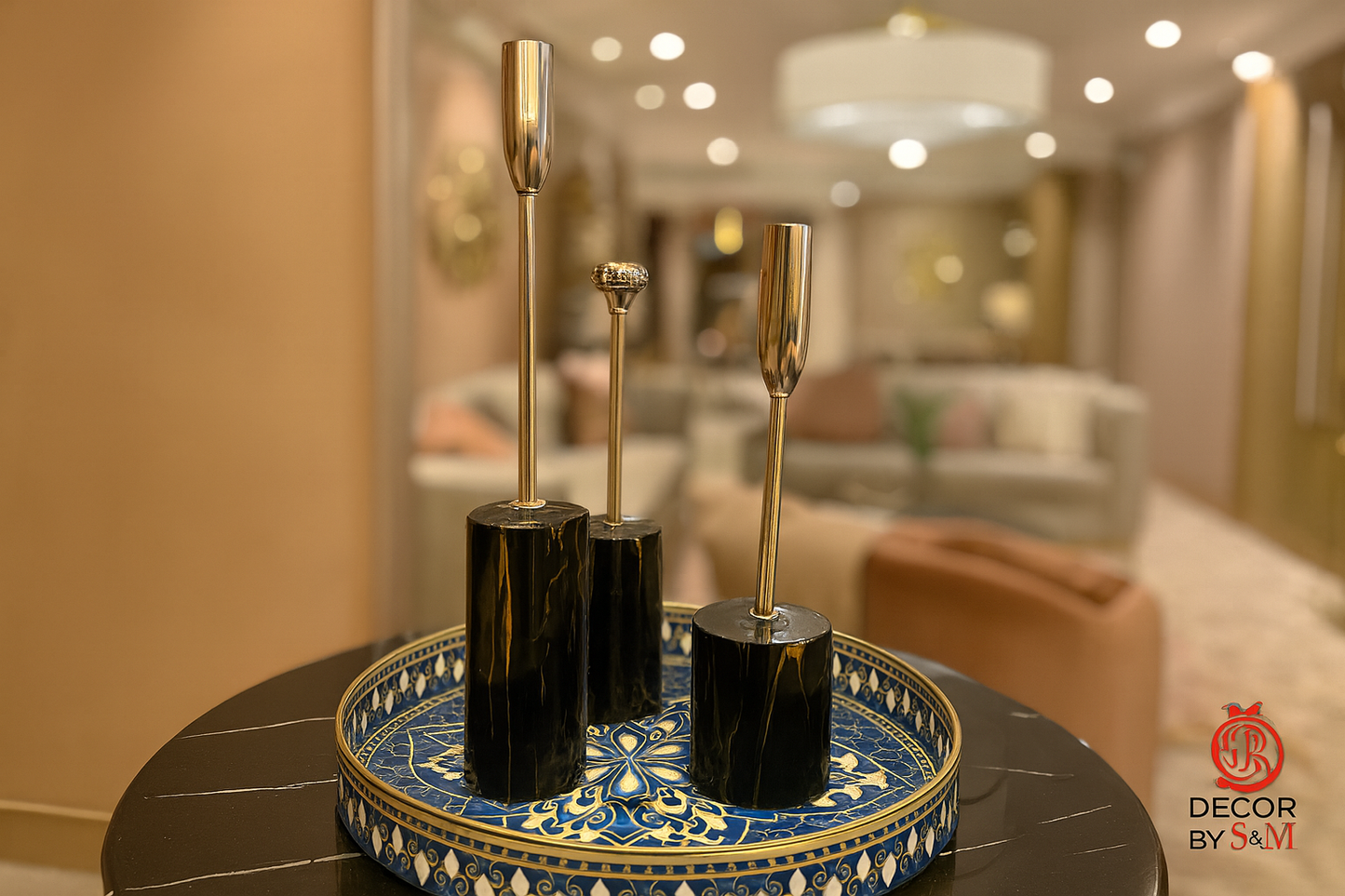 Black marble candlesticks on blue porcelain tray on glass table in contemporary living space