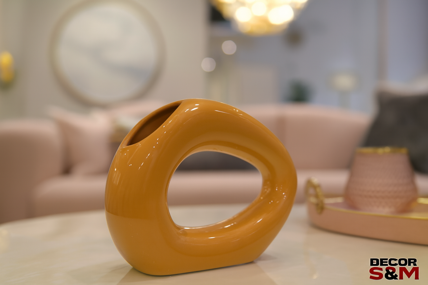 Orange ceramic sculpture with asymmetrical design on glass table in contemporary living space