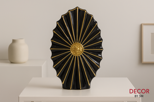 Black and gold decorative fan sculpture with minimal background