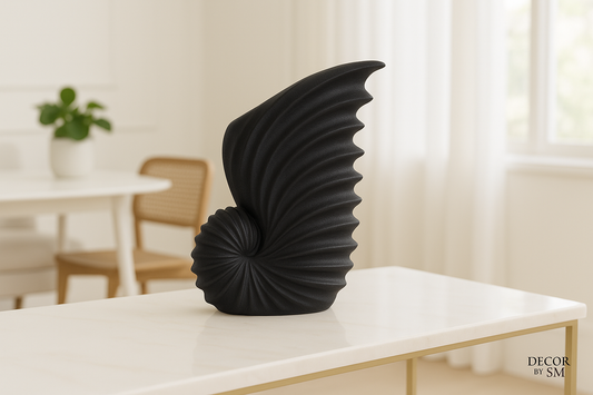 Black sculptural wing-shaped vase with light background