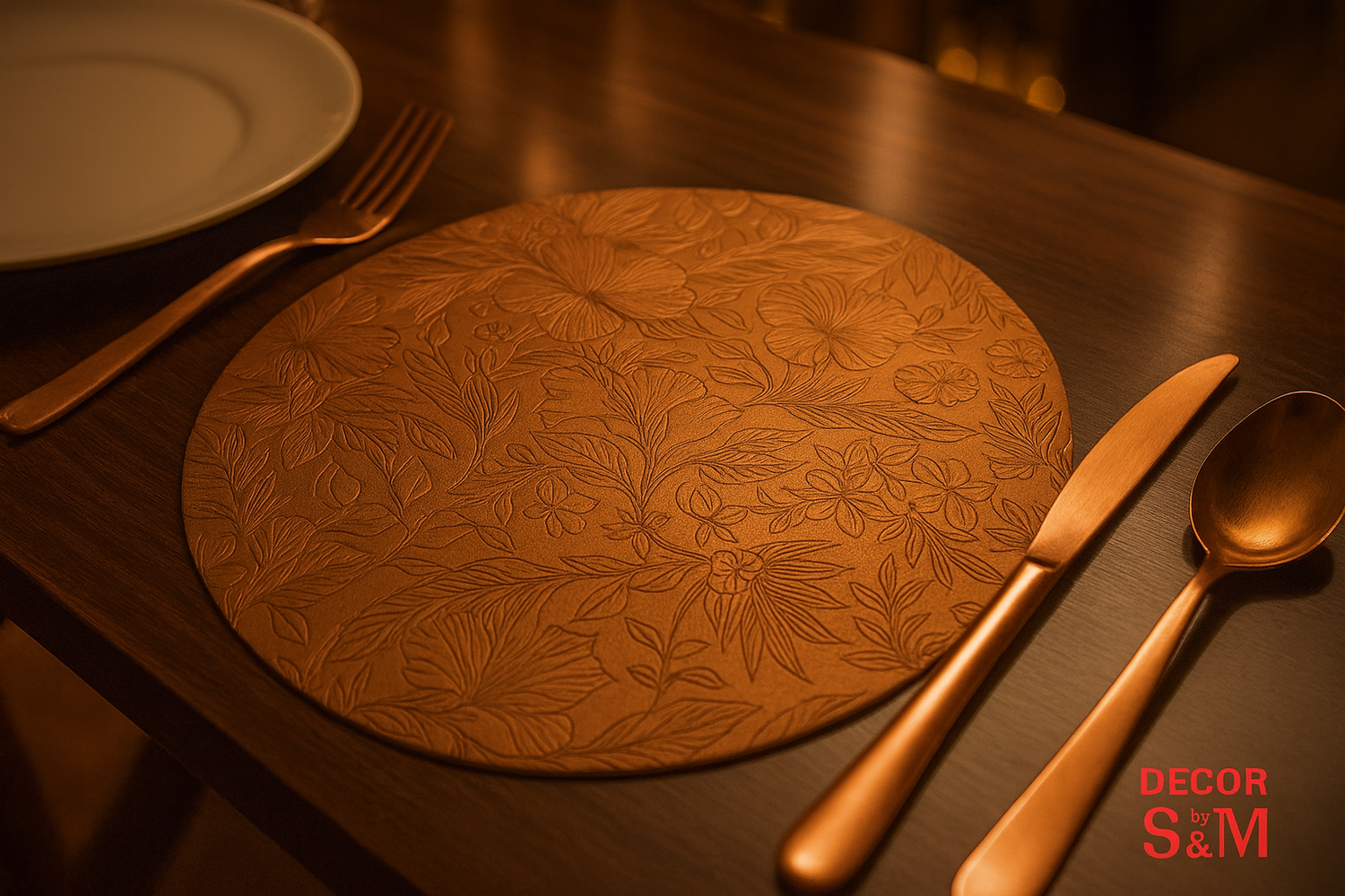 Copper table mat with floral engravings and bronze cutlery on dining table