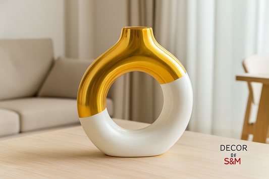 Gold and white ring-shaped vase on table in minimal interior