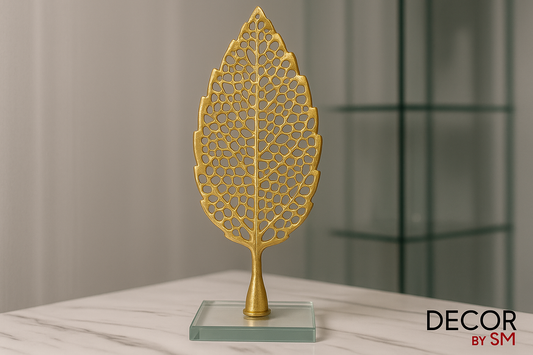 Golden leaf sculpture on crystal base with glass elements in background