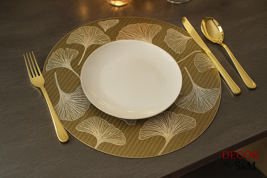 Metallic ginkgo leaf pattern table mat with gold cutlery on dining table