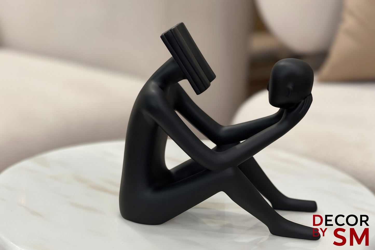 Modern black reading figure on white coffee table in contemporary living space