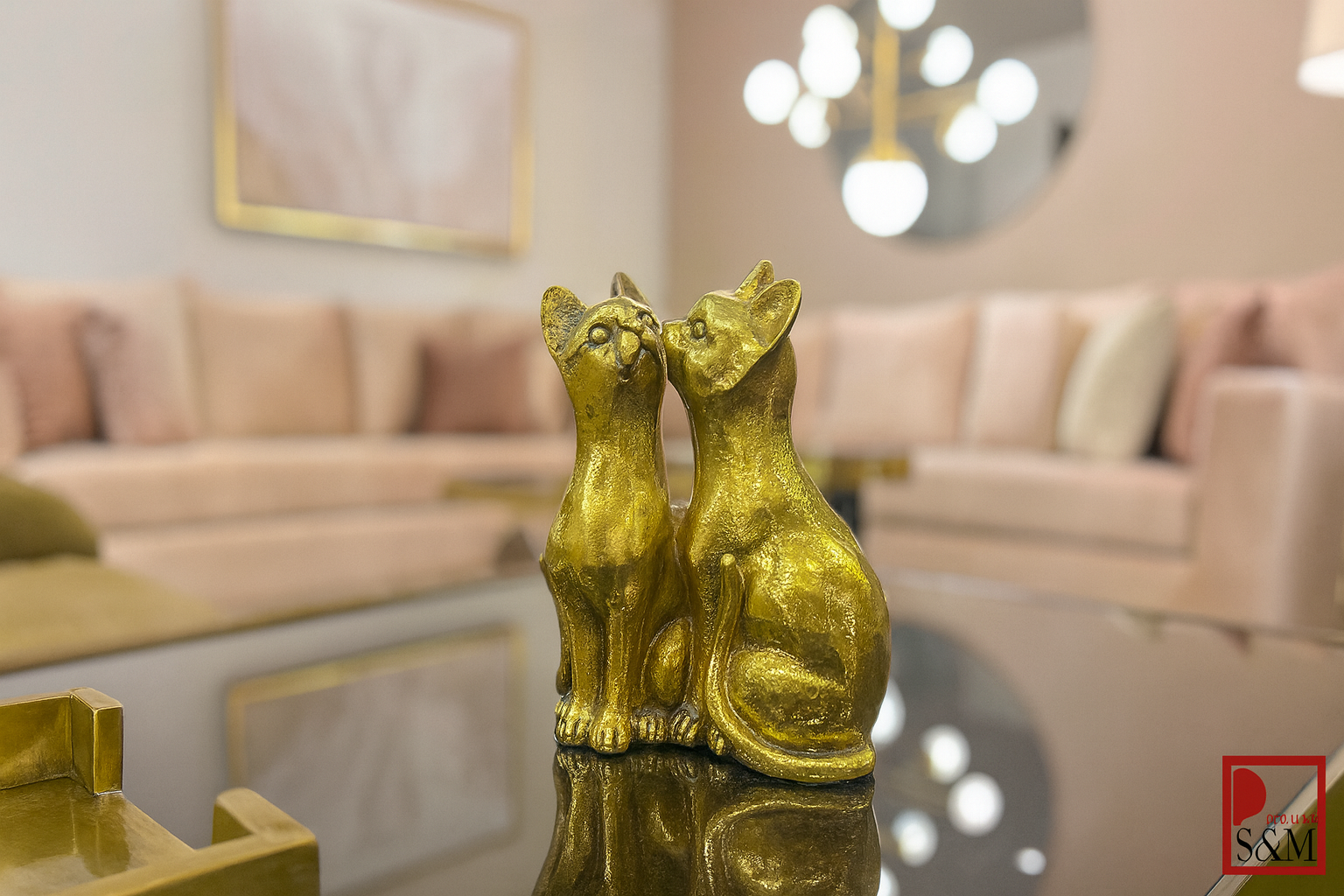 Pair of golden cat figurines on glass table in contemporary living space