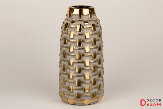 Tall metallic vase with basket-weave pattern on warm white background